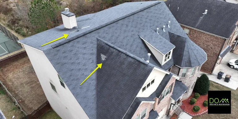 Aerial drone view of hail and wind damage on a roof in Cumming, showing missing and damaged shingles identified by Dom Roofing & Restoration.
