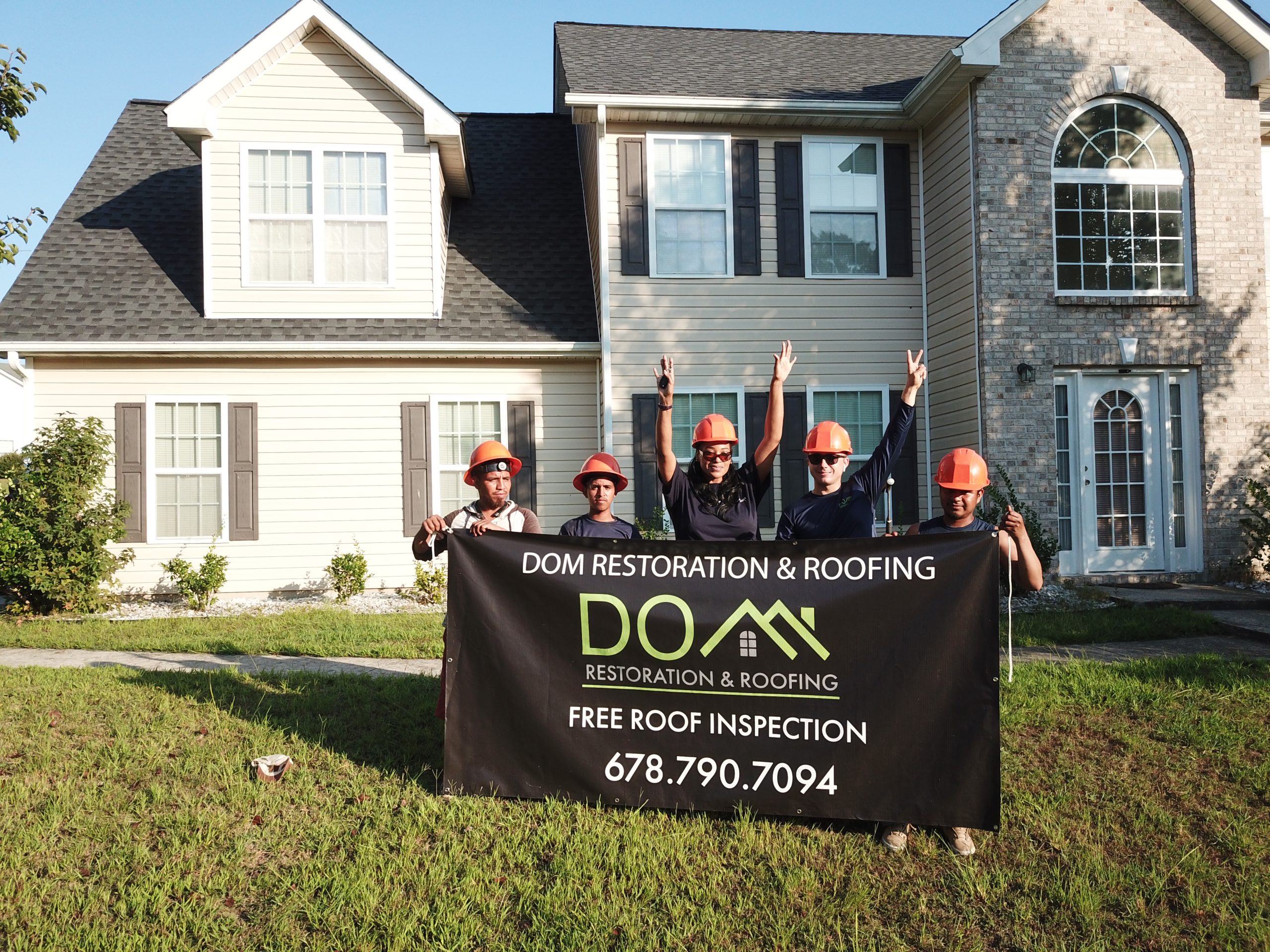 Dmitryi and the professional Dom Roofing & Restoration team of expert roofers standing proudly in front of their done project in Sugar Hill, GA.