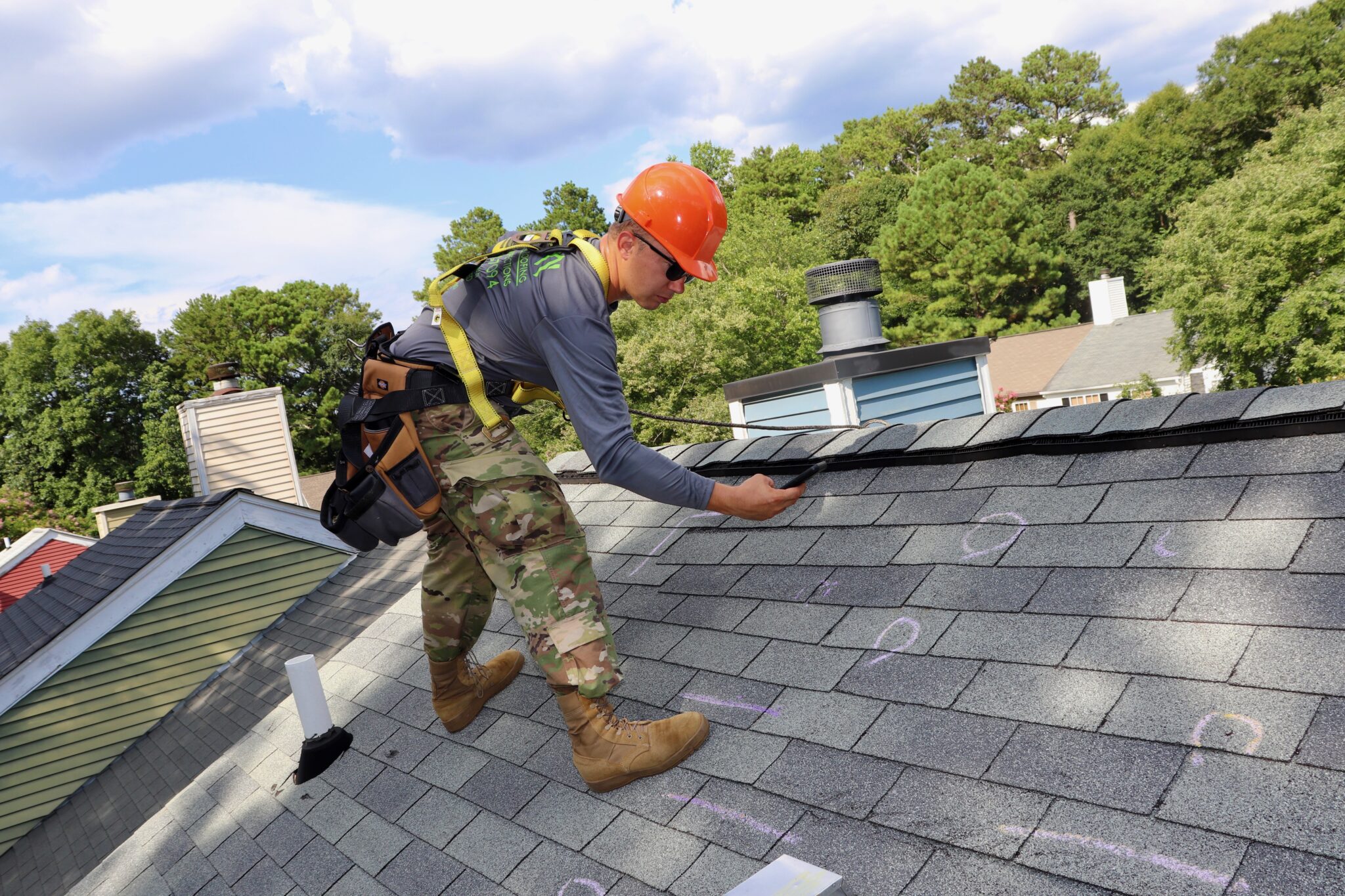 Dacula, GA Roofing | Dom Roofing & Restoration 2 Dom Roofing inspector marking hail damage with chalk during a storm damage roof inspection