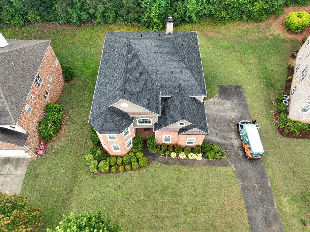 Best Atlanta Roofing Company 1 Dom Roofing van at a completed charcoal shingle roof replacement on a brick home in the Atlanta metro