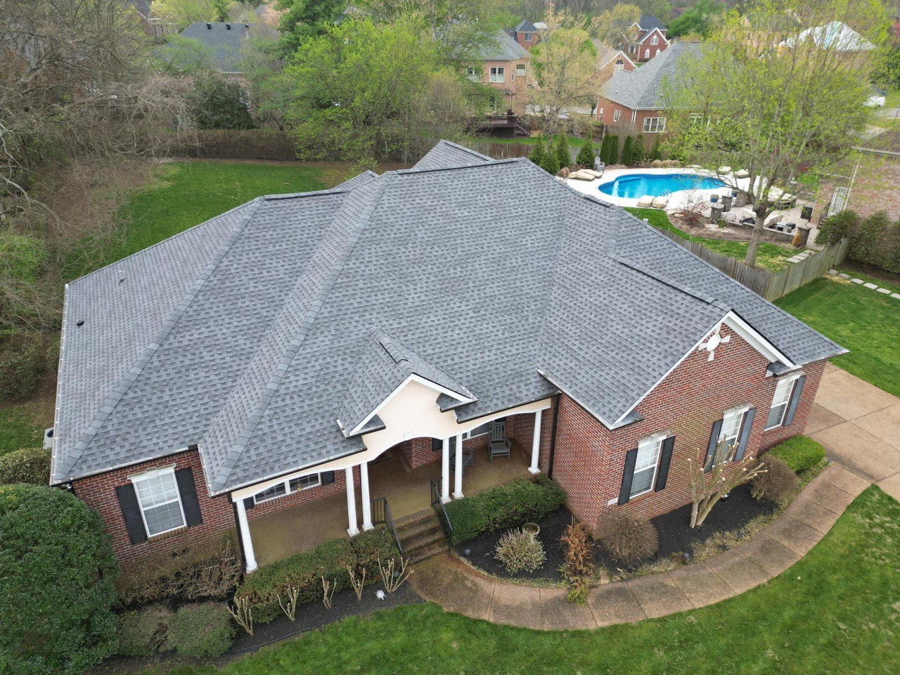 Roofing Company in Roswell, GA 1 Aerial view of a new architectural shingle roof on a brick home with pool by Dom Roofing, serving Roswell, GA