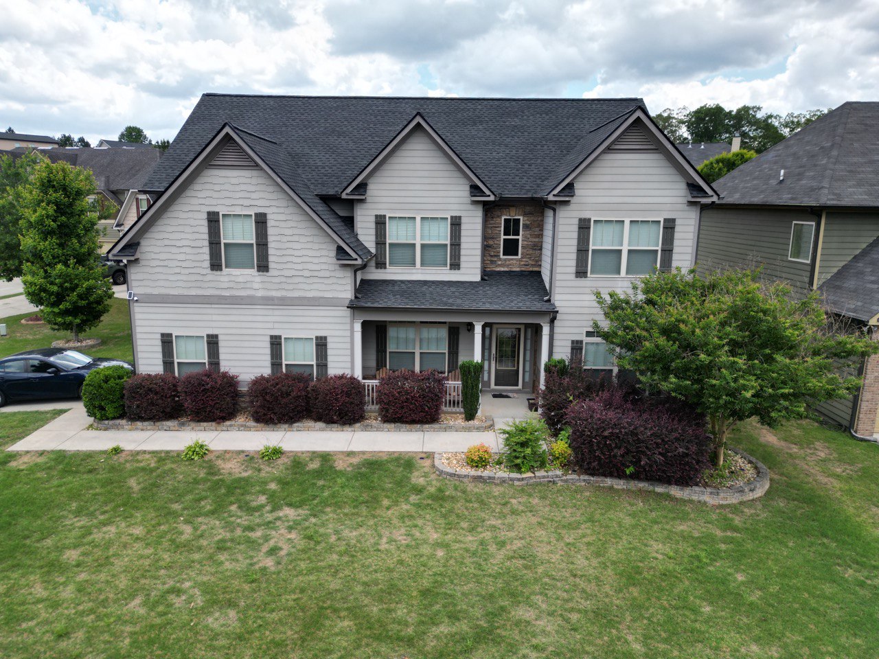 Roofing Company in Smyrna, GA 1 Completed black architectural shingle roof on a two-story home by Dom Roofing, serving Smyrna, GA