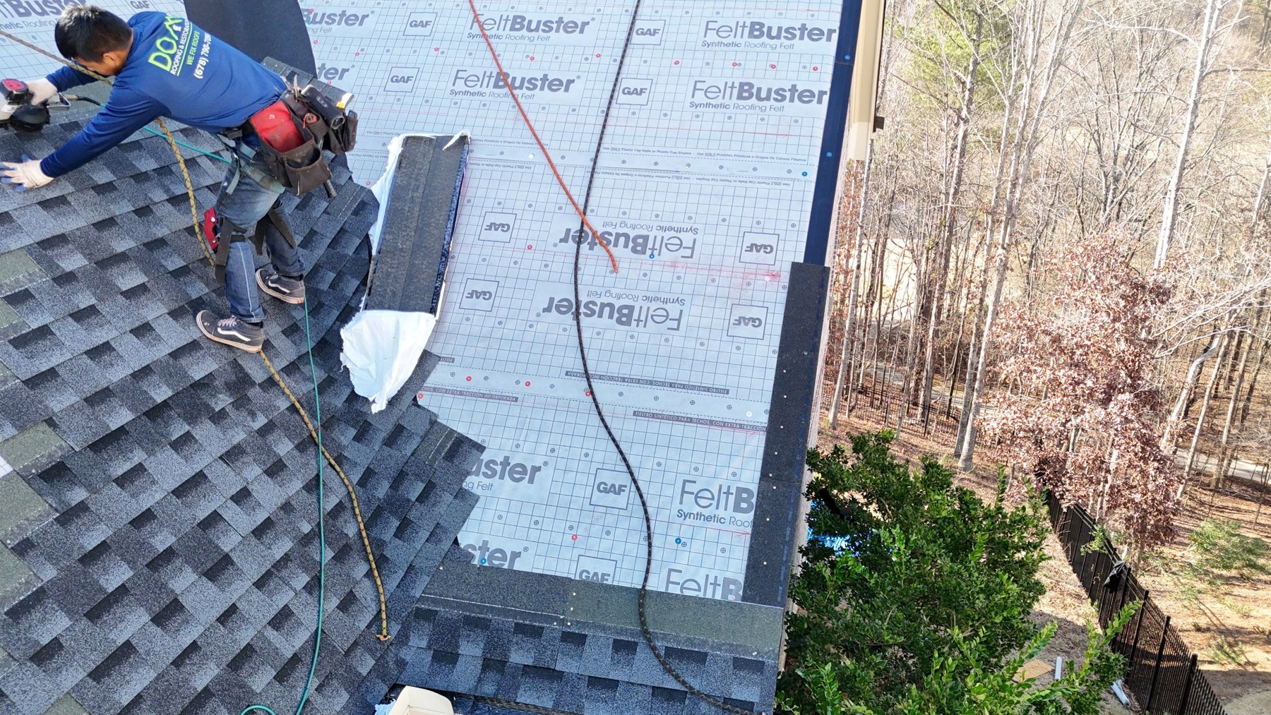 Drip Edge: Why Georgia Roofs Fail Without It 1 Roofer installing shingles near a roof edge covered with underlayment