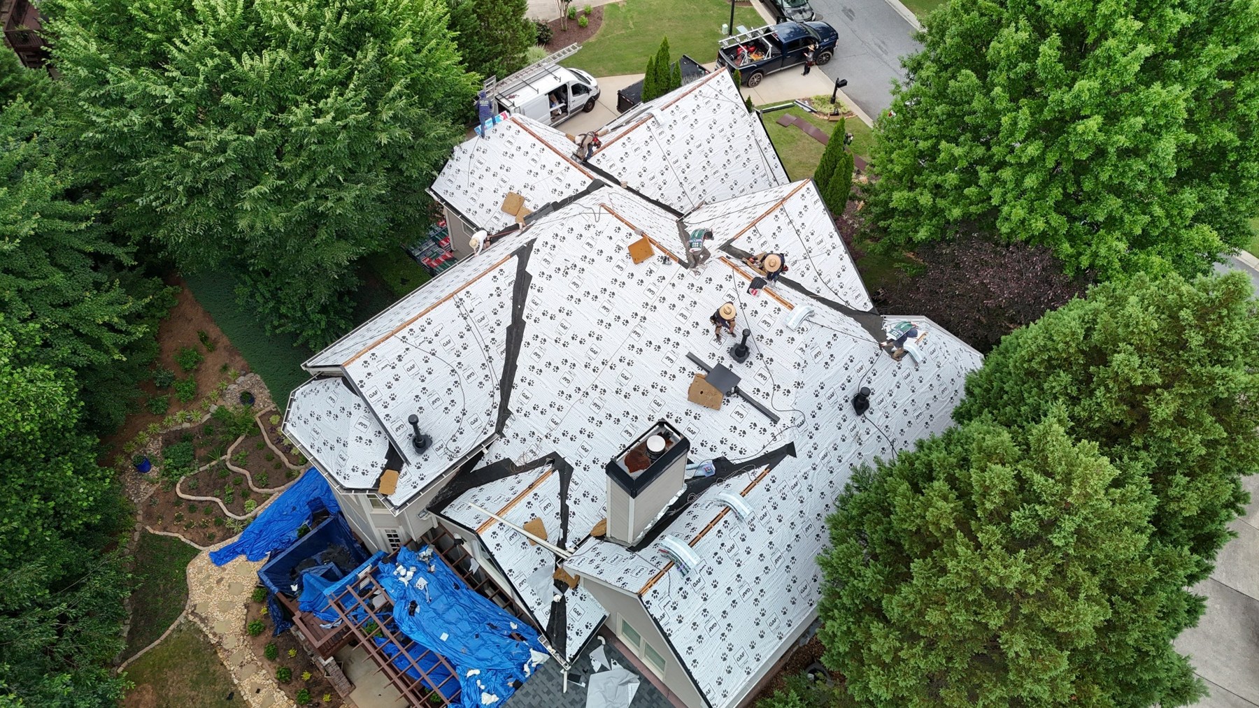 dom-real-synthetic-01 Aerial view of a roof covered with synthetic underlayment during installation