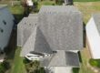 Aerial inspection photo of an asphalt shingle roof with dark streaks and uneven discoloration