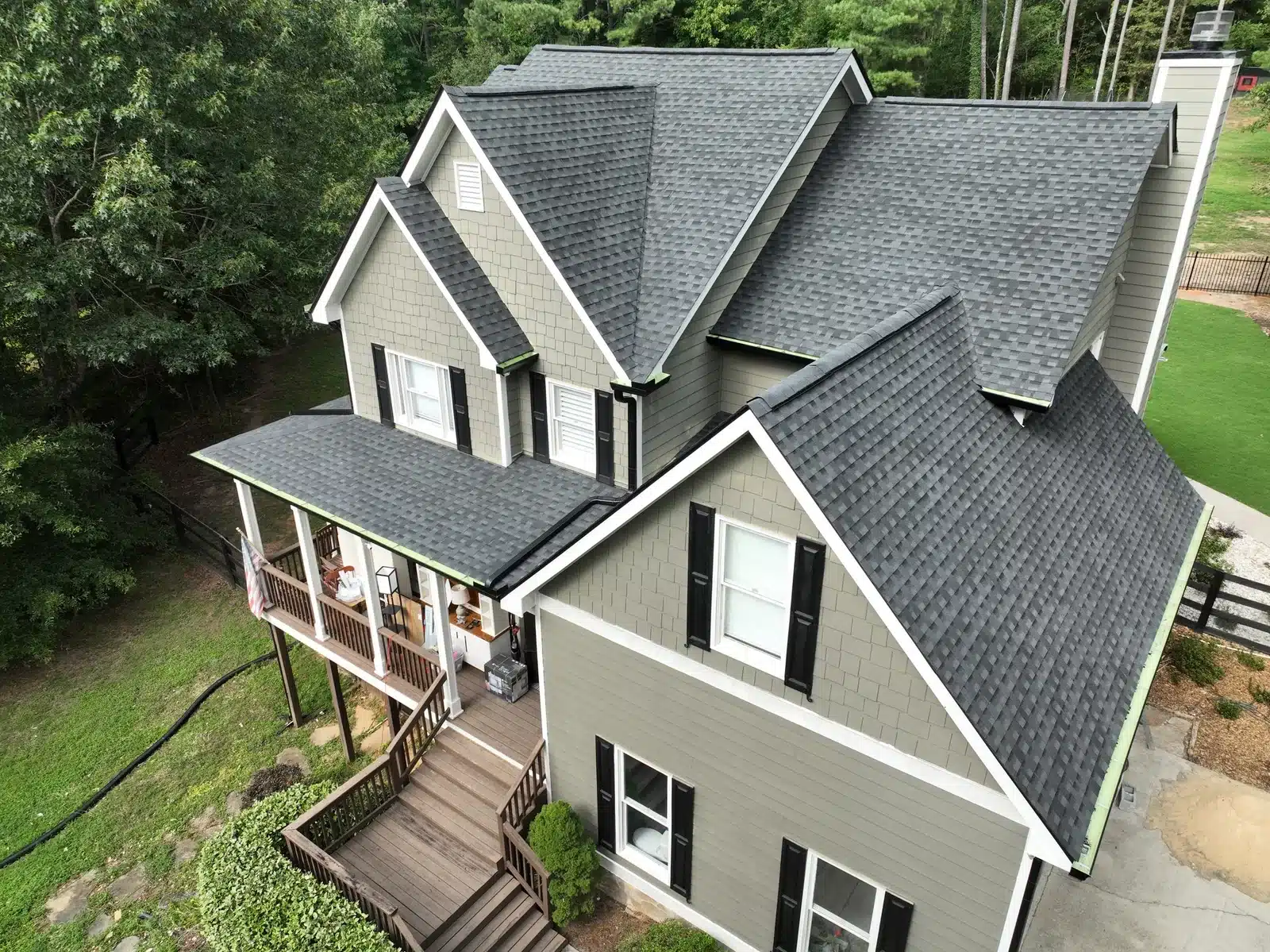 DOM Roofing and Restoration shingle roof replacement Gray shingle roof with multiple gables and valleys on a two-story home.